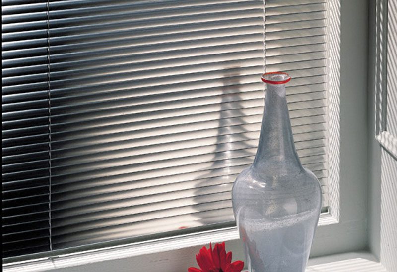 Aluminum mini blinds mounted side by side in a large window
