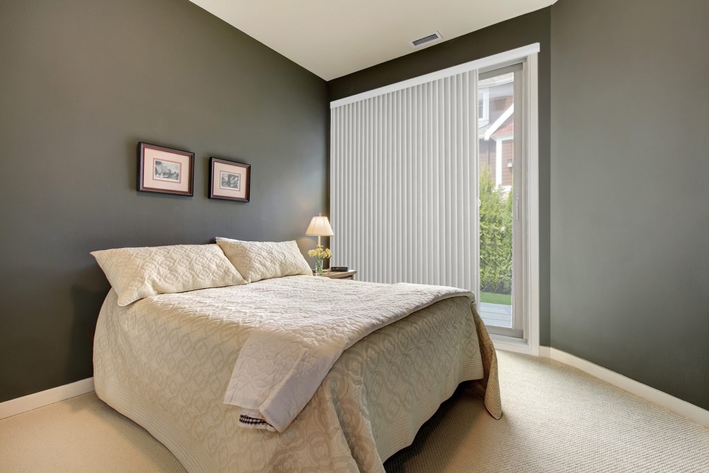 Vertical cellular shades in a bedroom providing insulation and light filtering
